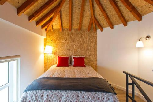 a bedroom with a bed with two red pillows at Matosinhos House Surf & Beach in Matosinhos