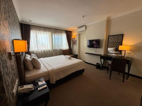 a hotel room with a bed and a desk at Merchant Hotel in George Town