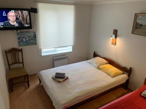 a bedroom with a bed and a tv and a chair at Piiri 12, white Apartment - 2 big beds - Very Cute Apartment in Tartu