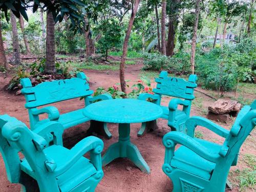 a blue table and four chairs in a park at Sigiri Lodge in Sigiriya