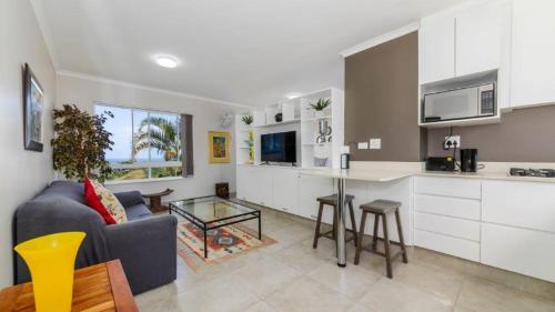 a kitchen and living room with a couch and a table at Bay Lodge 29 in Ballito