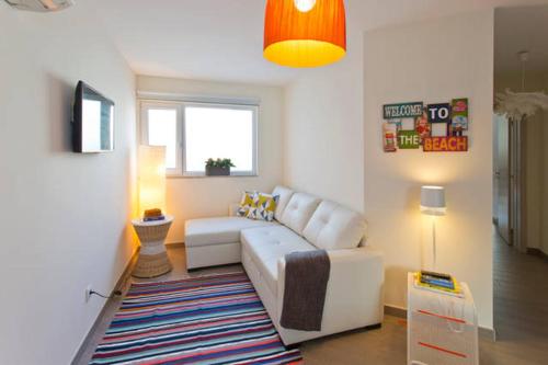 a living room with a white couch and a window at Matosinhos House Surf & Beach in Matosinhos