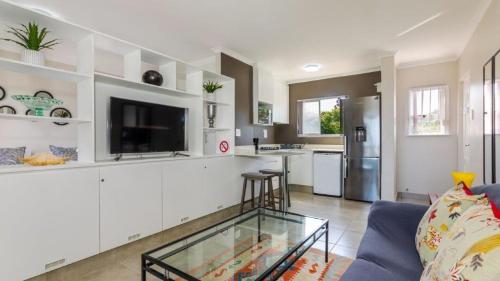 a living room with a blue couch and a kitchen at Bay Lodge 29 in Ballito