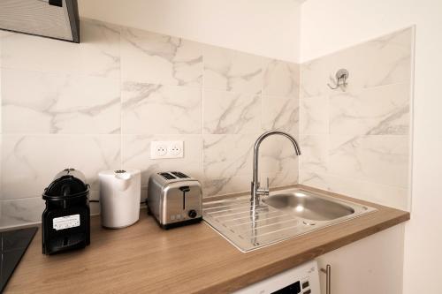 Il comprend une cuisine équipée d'un évier et d'un grille-pain. dans l'établissement Charming studio in Versailles - Welkeys, à Versailles