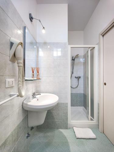 a white bathroom with a sink and a shower at Hotel Naica in Rimini