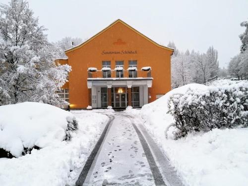 a building covered in snow in front of a road at Lázně Meziboří in Meziboři
