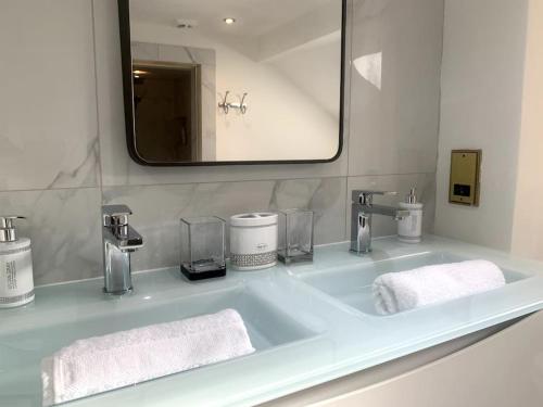 a bathroom sink with two towels and a mirror at WestLaigh Central Scotland with outdoor BBQ Hut, pets welcome in Strathaven