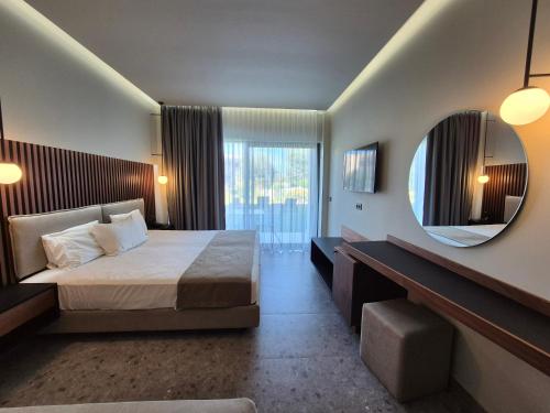 a hotel room with a bed and a mirror at Thassos Imperial Resort in Skala Rachoniou