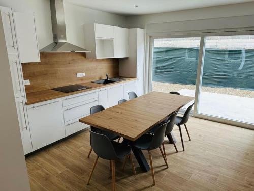 a kitchen with a wooden table and some chairs at Europapark à 11km Maison Soleil climatisé in Friesenheim