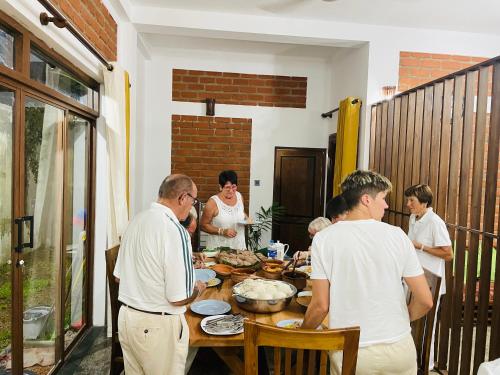 a group of people standing around a table at Nivartana Villa and Purana Ayurveda Center in Bentota