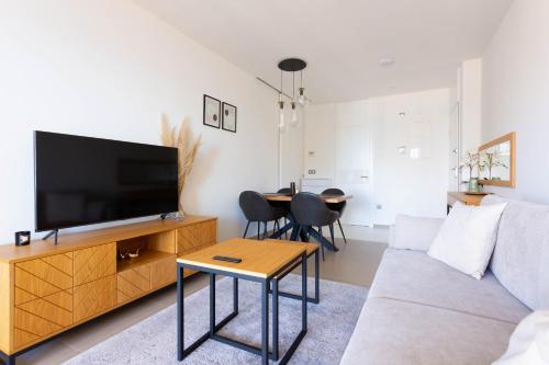 Una sala de estar con un sofá y un televisor. en Intempo by Holuxe - 131 - 13th floor, en Benidorm