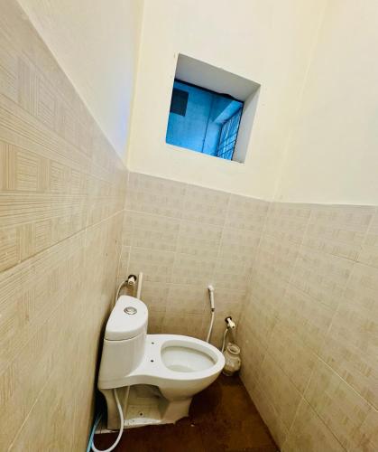 a bathroom with a toilet and a window at Pansota House in Faisalabad