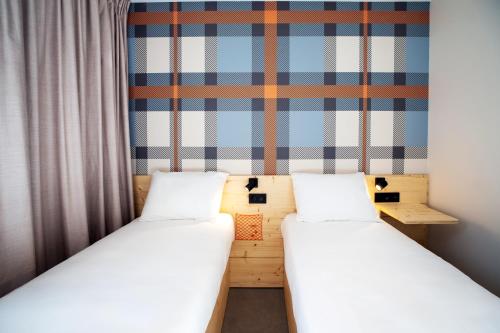 two beds in a room with a wall at easyHotel Marseille Euromed in Marseille