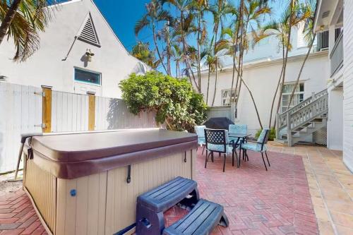 a backyard with a grill and chairs and a house at Duval Street Retreat in Key West