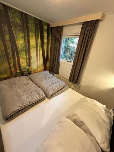 a white bed in a room with a window at Chalet Woef op de Veluwe in Doornspijk