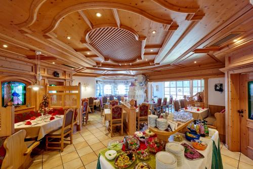 una sala da pranzo con tavoli e sedie e una sala piena di cibo di Hotel Brunnenhof a Bayerisch Eisenstein