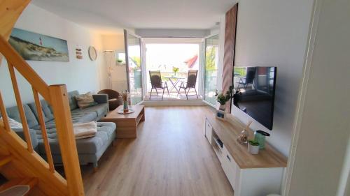レリクにあるFerienwohnung OstseeStern Rerik mit Saunaのソファとテレビのあるリビングルーム