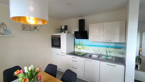 レリクにあるFerienwohnung OstseeStern Rerik mit Saunaの白いキャビネットと木製のテーブルのあるキッチン
