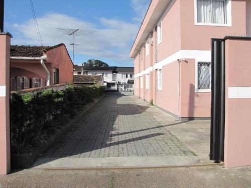 an alley way between two pink buildings at RCM Vilas - Studio n 14 in Joinville
