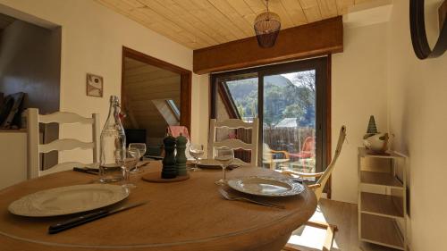 une table en bois avec des assiettes et des verres à vin dessus dans l'établissement Centre Village - 50m2 Rénové Vue montagne avec Balcon plein Sud - 4-5pers, à Luz-Saint-Sauveur