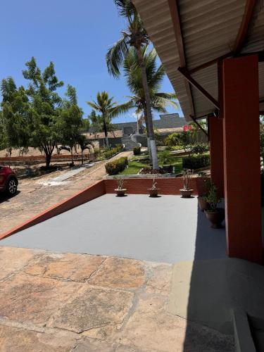 a concrete patio with a palm tree in the background at Pousada Recanto das Orquídeas in Barreirinhas