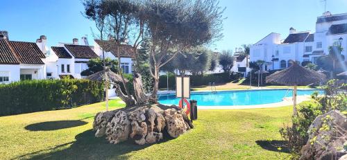 エステポナにあるE1 Desk Private patio Terrace Barbecueの木の木の芝生のプールサイド