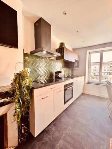 a kitchen with white cabinets and a large window at Bella Vita Epinal in Épinal