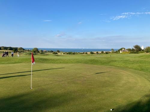 a golf course with a flag on a green at Broadstairs, Bays & Golf - Sleeps 2 in Broadstairs