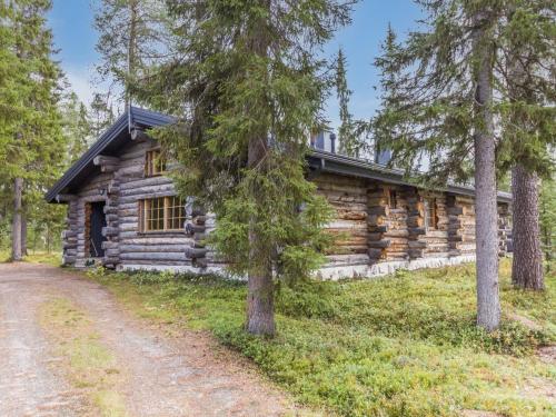 eine Blockhütte im Wald mit einer Feldstraße davor in der Unterkunft Holiday Home Kuusi-ruka 6 by Interhome in Rukatunturi 