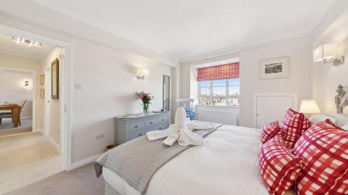 a white bedroom with a bed and a window at Nell Gwynn Chelsea Accommodation in London