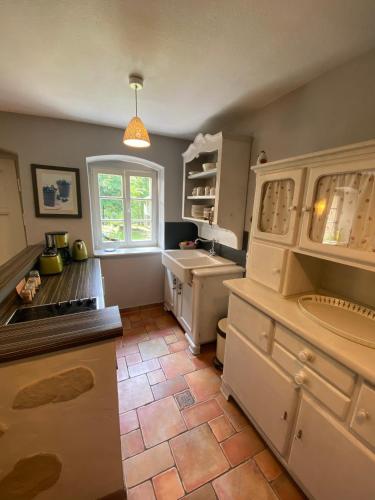 a kitchen with white cabinets and a tile floor at Wanderer Paradies in Pirna