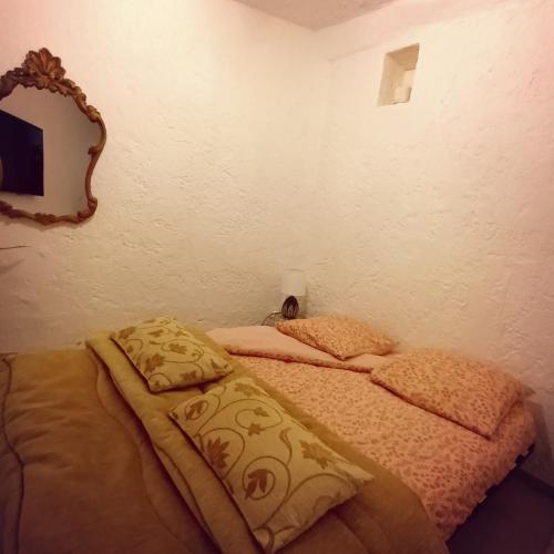Cette chambre comprend un lit avec deux oreillers et un miroir. dans l'établissement Joli havre de paix, à Vence