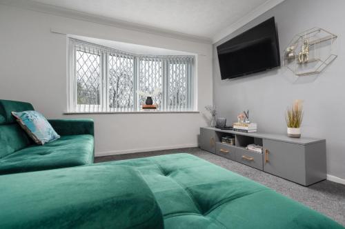 a living room with a green couch and a flat screen tv at Hillcrest Apartments in Birmingham