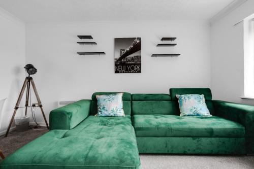 a green couch in a living room with a camera at Hillcrest Apartments in Birmingham