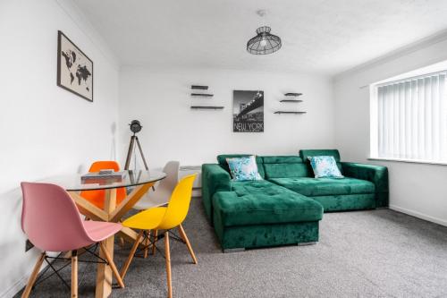 a living room with a green couch and a table at Hillcrest Apartments in Birmingham