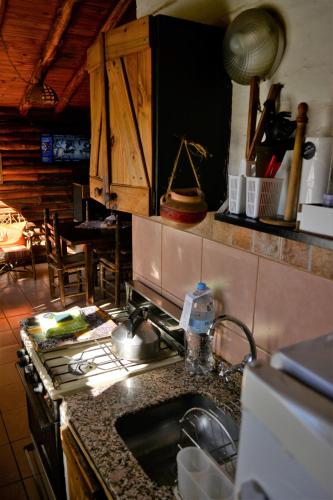 a kitchen with a sink and a stove top oven at Kpriccio Cabanas in Potrerillos