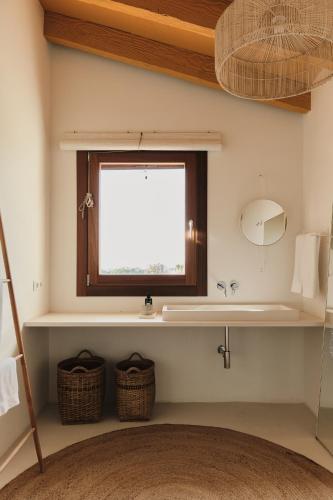 a bathroom with a sink and a window at Amagatay Luxury Boutique Hotel - Adults Only in Alaior