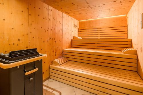 a sauna with wooden walls and a stove at Nationalparkhotel Klockerhaus in Krimml