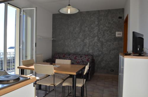 a dining room with a table and chairs and a couch at Residence Villa Carmen fronte mare a 50 mt in Pietra Ligure