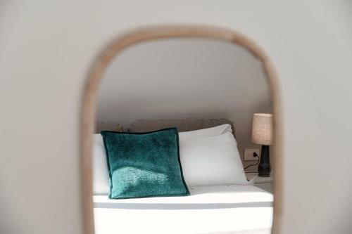 a white bed with a green pillow on it at Lario Suite Apartments by Quokka 360 - With parking Next to Como City in Como