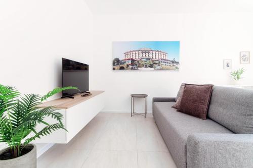 a living room with a couch and a tv at Lario Suite Apartments by Quokka 360 - With parking Next to Como City in Como