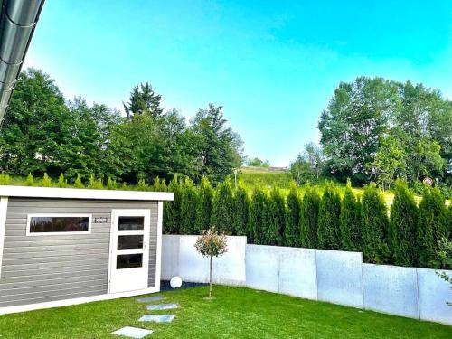 a small shed in a yard next to a fence at Ferienhaus Belvedere am Schluchsee in Schluchsee