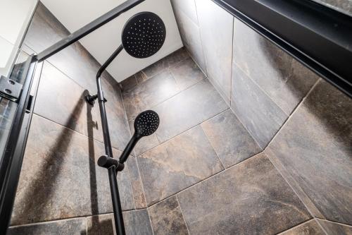 a shower in a bathroom with a tile floor at Wild Berry Stays - Swan Street A in Angus