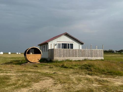 a house in the middle of a field with a mirror at Cave Cabins in Hella