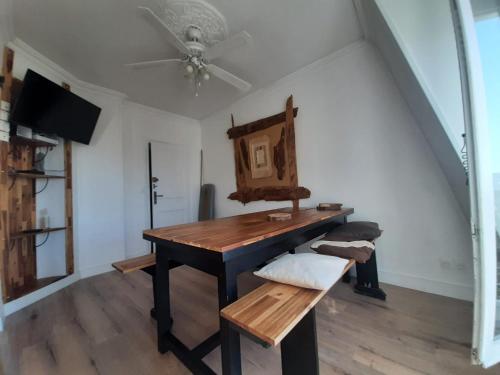Cette chambre dispose d'une table en bois et d'un ventilateur de plafond. dans l'établissement Appartement 3 pièces Gare de Lyon Bercy Arena 75012 Paris, à Paris