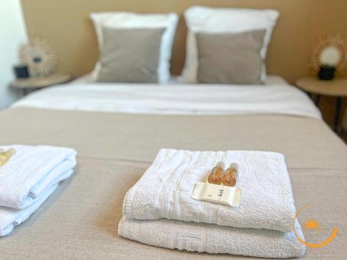 two beds with towels and a box of donuts on them at T3 Luxueux Bali Côté Mer & Tram - Lattes in Lattes