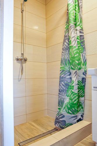 a shower with a shower curtain in a bathroom at Farma Serock in Serock