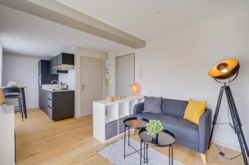 un salon avec un canapé et une cuisine dans l'établissement MDOR - L'Hôtel de Ville, à Bordeaux