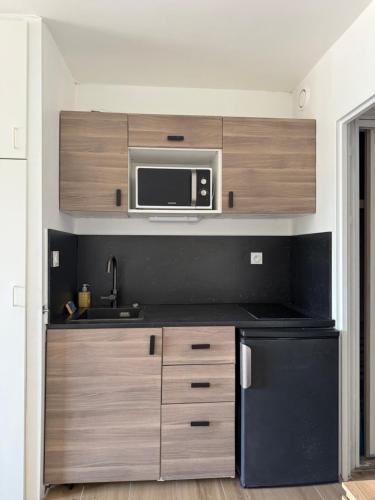 une cuisine avec un évier et un micro-ondes dans l'établissement Super studio climatisé sur le port de Hyeres, à Hyères