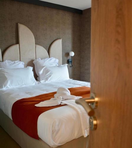 une chambre d'hôtel avec un lit et un peignoir dans l'établissement Hôtel Breizh Du Golfe, à Arzon